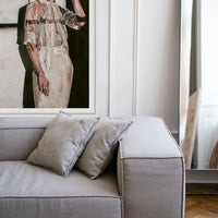 Gray sofa with decorative pillows in a room with a framed art print on the wall.