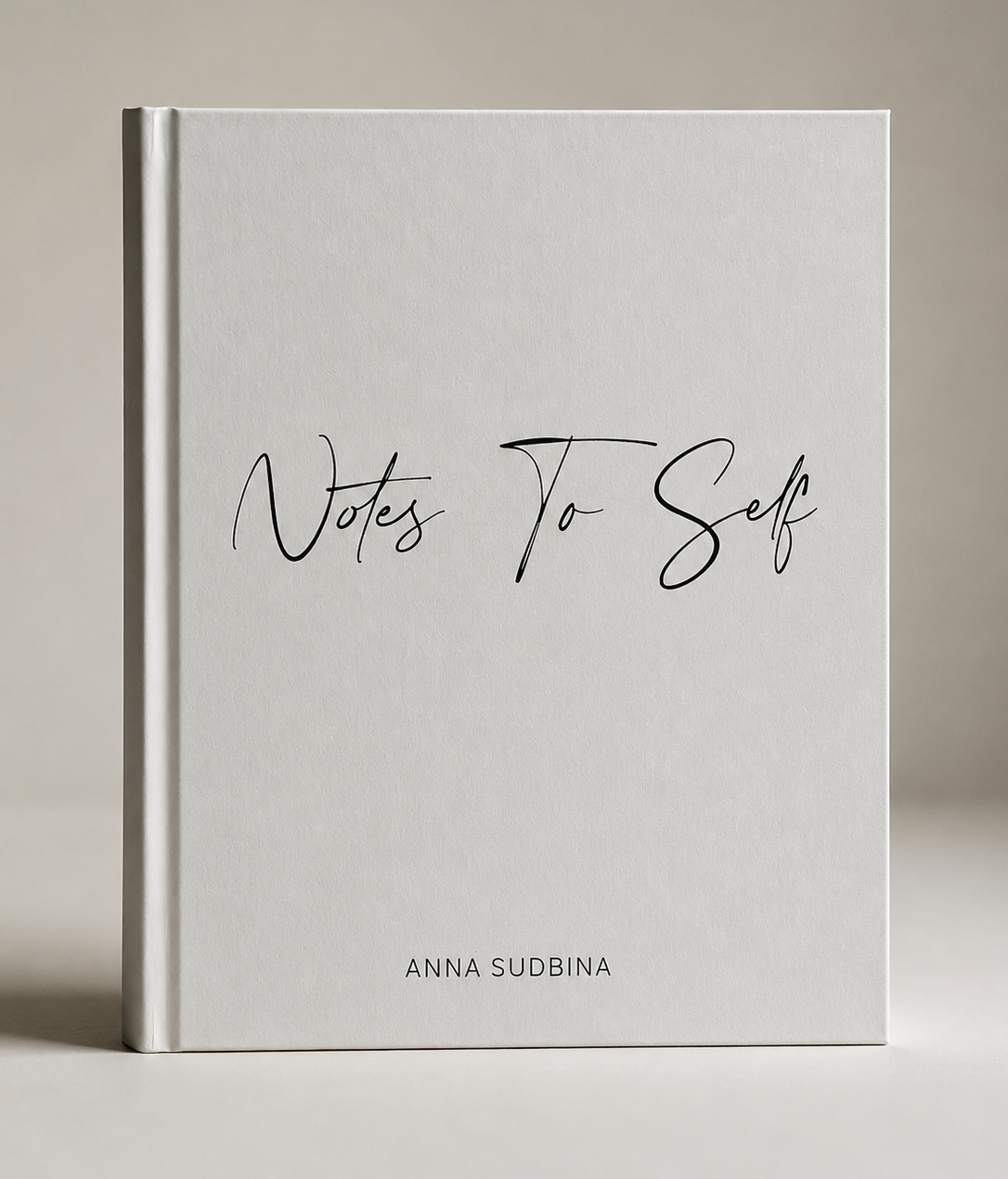 A hardcover artist book titled 'Notes To Self' by Anna Sudbina, featuring a minimalist white cover with black script text, set against a neutral beige background.