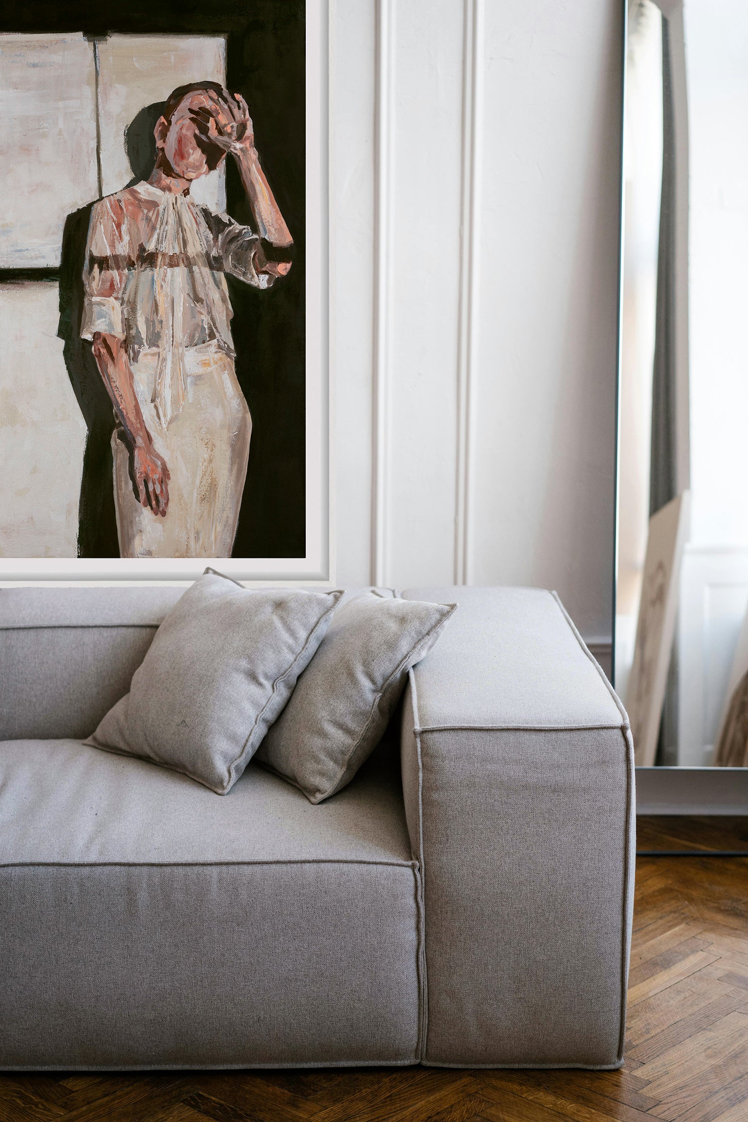 Large original figurative art print on wall above gray sofa with pillows, contemporary artwork for collectors